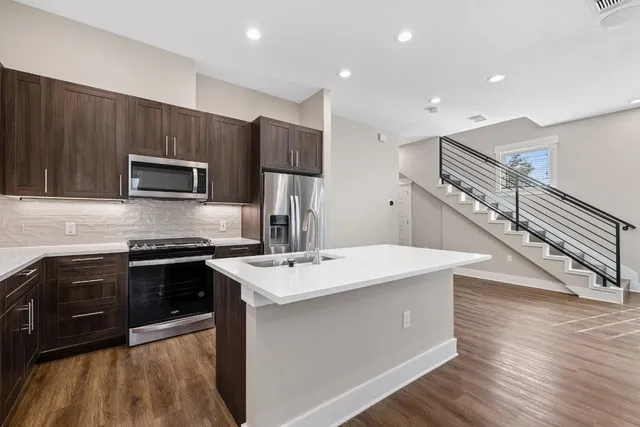 a kitchen with a sink a microwave a stove and refrigerator