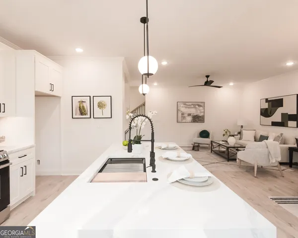 a kitchen with kitchen island a dining table chairs a sink and cabinets