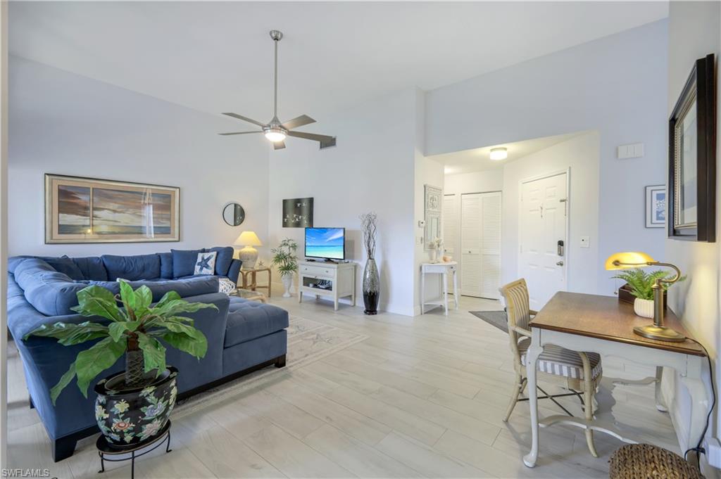 a living room with furniture a chandelier and a window