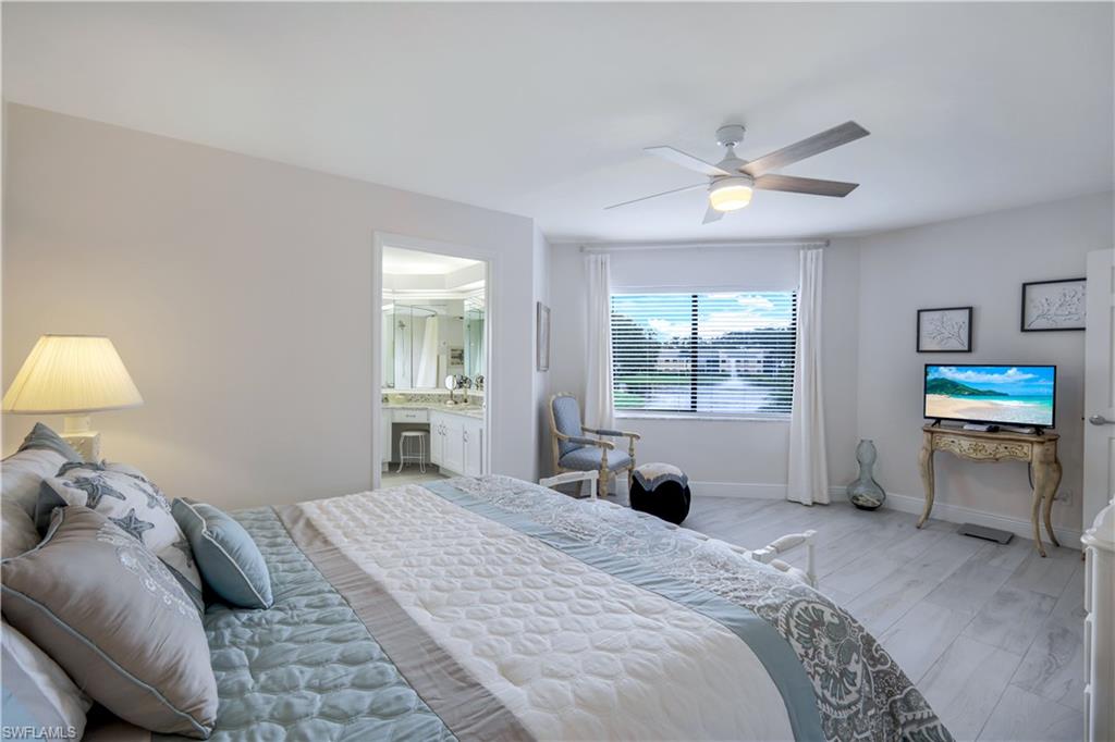 637 Beachwalk Circle, Unit E203 Naples, FL 34108 - Photo 12 of 30 a bedroom with a bed and a window