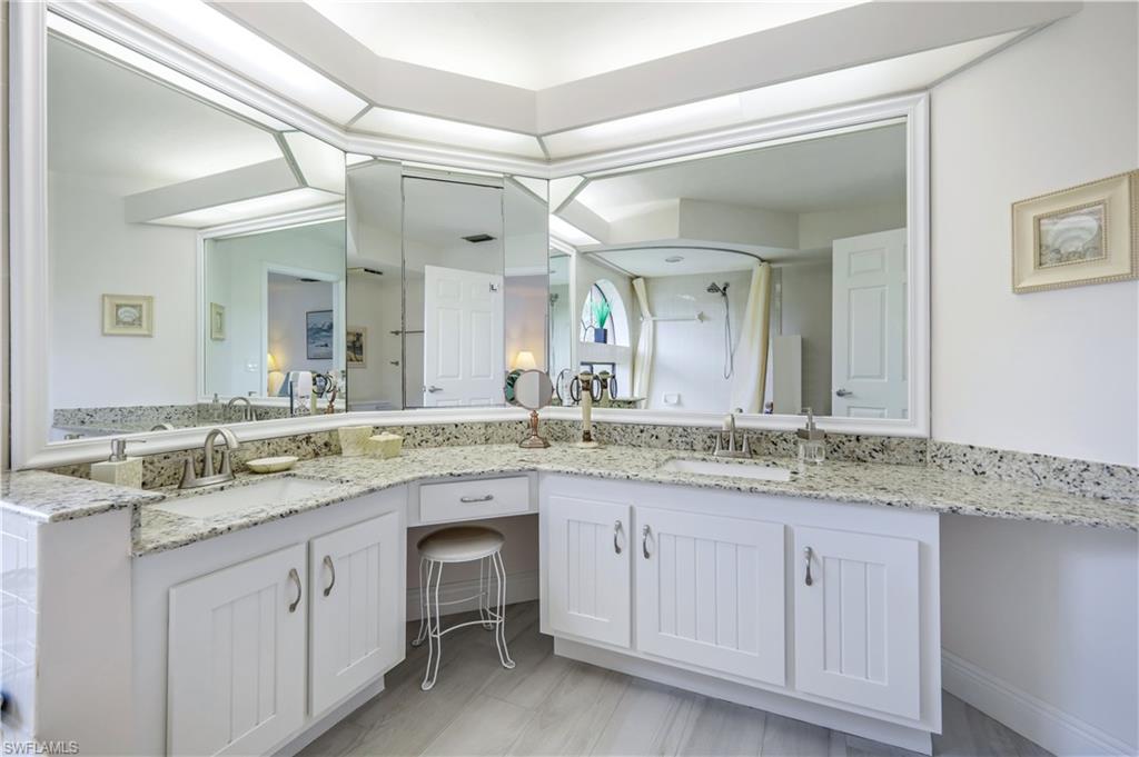 637 Beachwalk Circle, Unit E203 Naples, FL 34108 - Photo 14 of 30 a bathroom with a granite countertop sink and a mirror