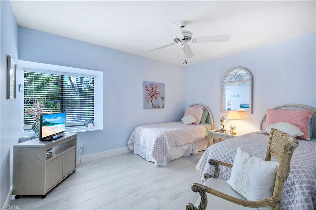 637 Beachwalk Circle, Unit E203 Naples, FL 34108 - Photo 15 of 30 a spacious bedroom with two beds and a window