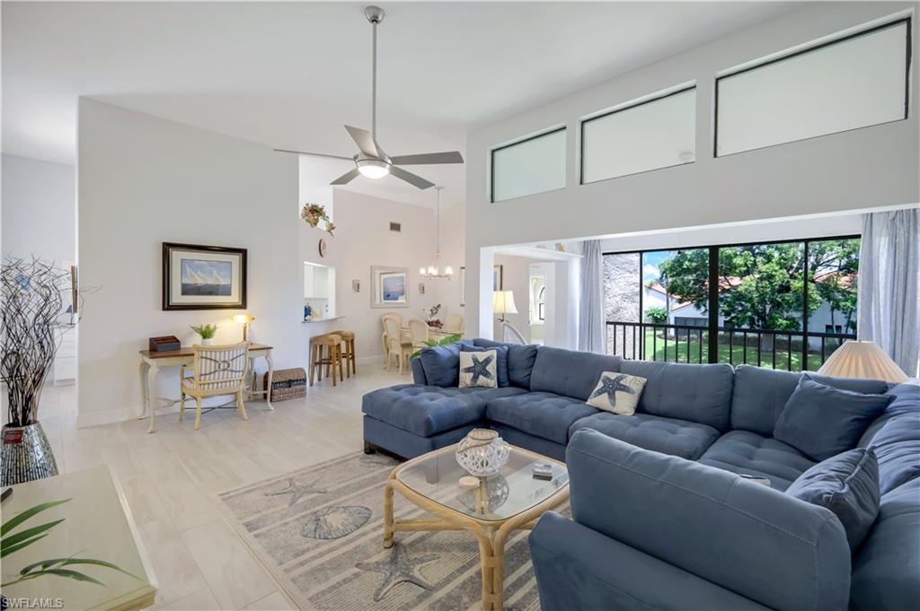 637 Beachwalk Circle, Unit E203 Naples, FL 34108 - Photo 2 of 30 a living room with furniture a table and a chandelier