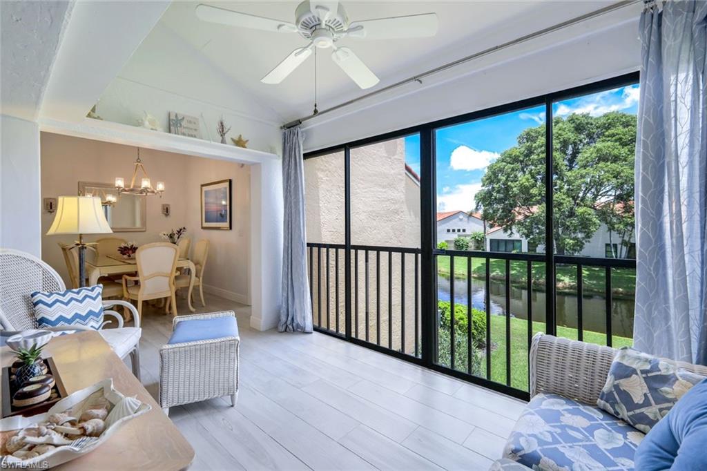 637 Beachwalk Circle, Unit E203 Naples, FL 34108 - Photo 4 of 30 a living room with furniture and a large window with wooden floor