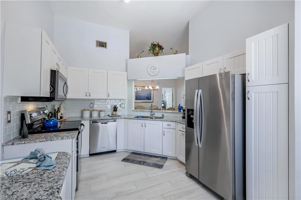 637 Beachwalk Circle, Unit E203 Naples, FL 34108 - Photo 6 of 30 a kitchen with a sink cabinets and stainless steel appliances