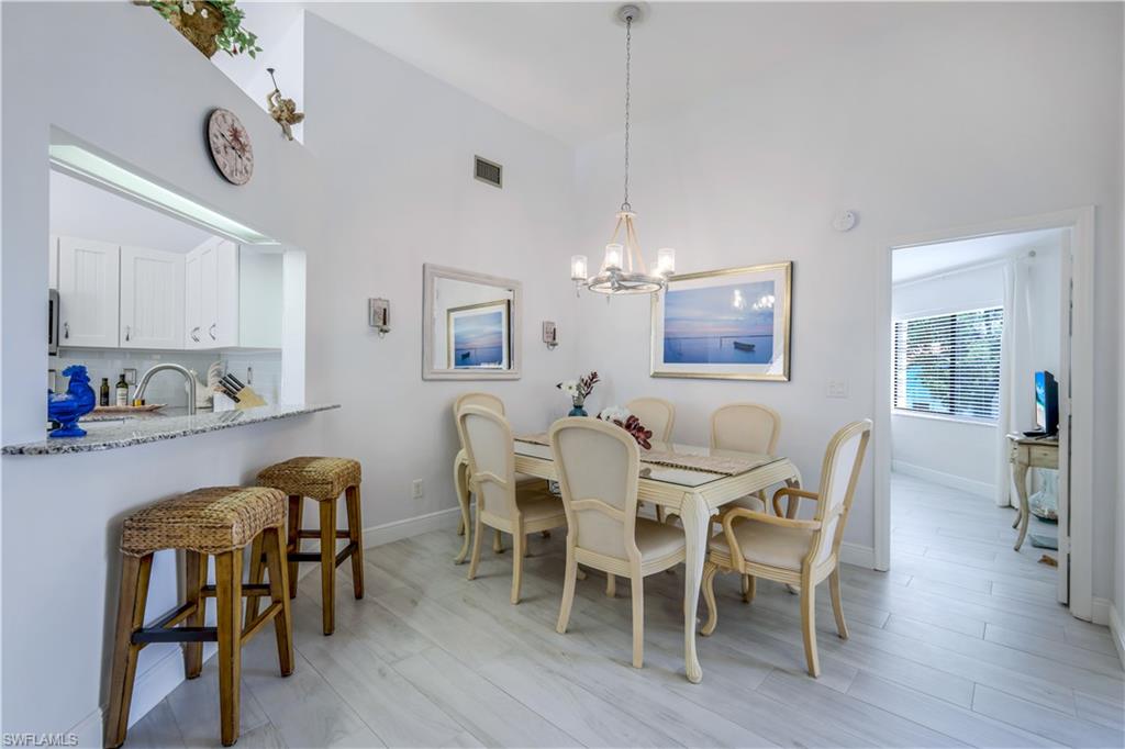 637 Beachwalk Circle, Unit E203 Naples, FL 34108 - Photo 9 of 30 a view of a dining room with furniture and wooden floor