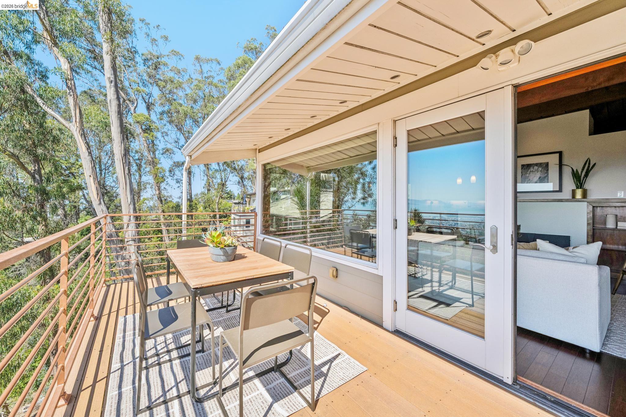 1394 Queens Road Berkeley, CA 94708 - Photo 20 of 63 Hardwood deck with horizontal metal railings, multiple pane windows, and a sliding glass door