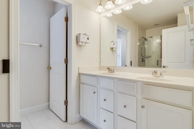 a bathroom with double vanity sinks a vanity a lamp and a mirror