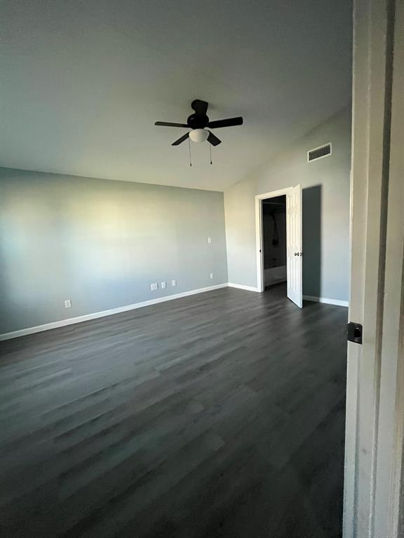108 North Ash Street Springtown, TX 76082 - Photo 12 of 22 an empty room with wooden floor a ceiling fan and closet