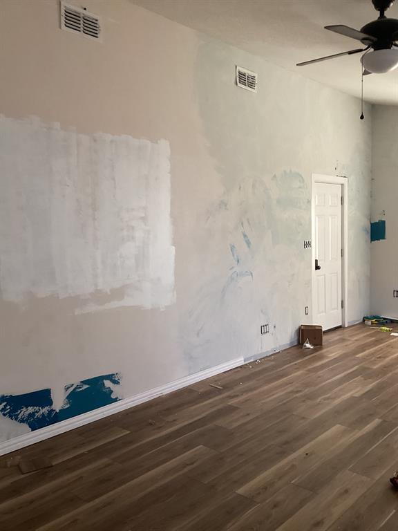 108 North Ash Street Springtown, TX 76082 - Photo 3 of 14 a view of wooden floor and windows in a room