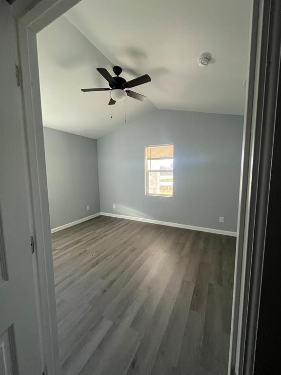 108 North Ash Street Springtown, TX 76082 - Photo 5 of 22 an empty room with wooden floor fan and windows