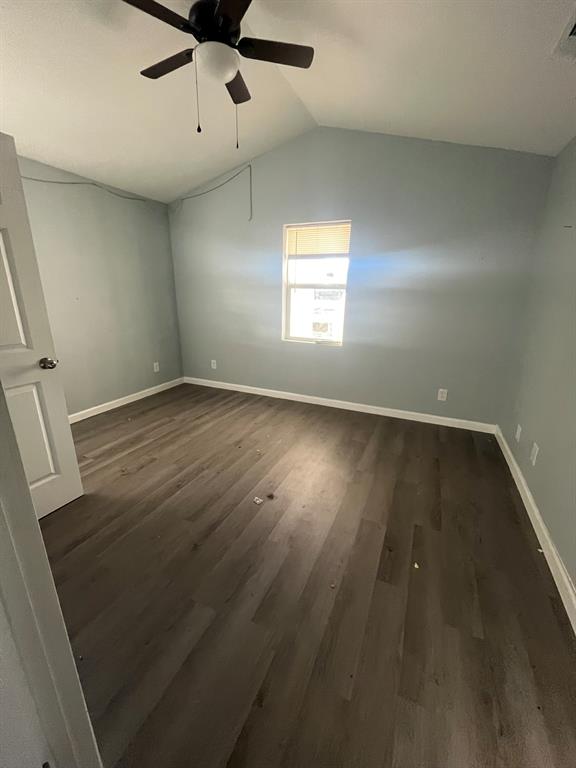 108 North Ash Street Springtown, TX 76082 - Photo 7 of 14 an empty room with wooden floor fan and windows