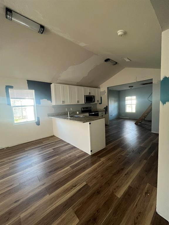 108 North Ash Street Springtown, TX 76082 - Photo 8 of 22 a view of kitchen and empty room with wooden floor