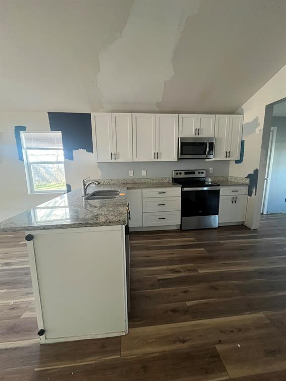 108 North Ash Street Springtown, TX 76082 - Photo 10 of 22 a kitchen with kitchen island granite countertop a sink stove and refrigerator