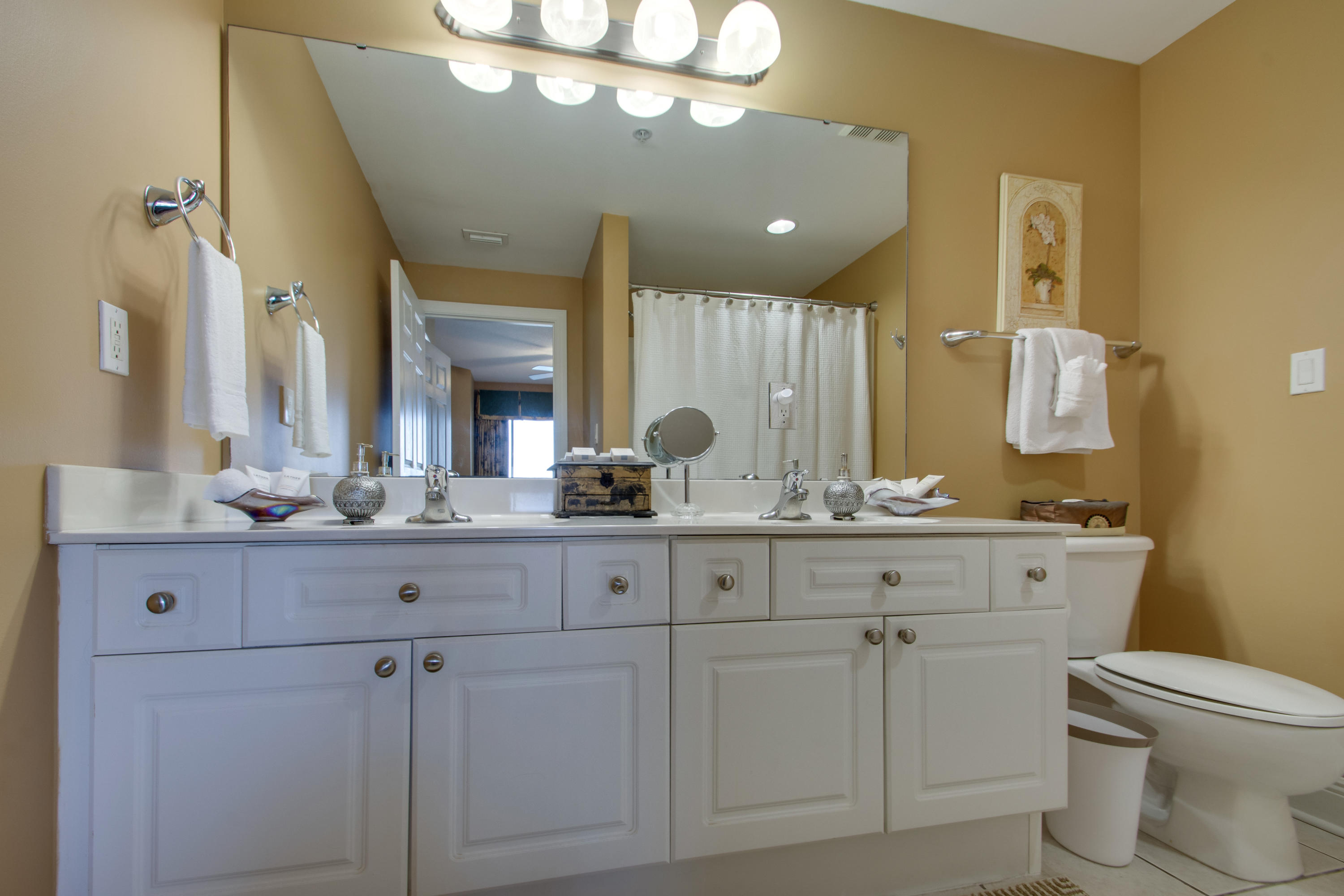 1111 Santa Rosa Boulevard, Unit 206 Fort Walton Beach, FL 32548 - Photo 18 of 46 a bathroom with a granite countertop sink a toilet and a mirror