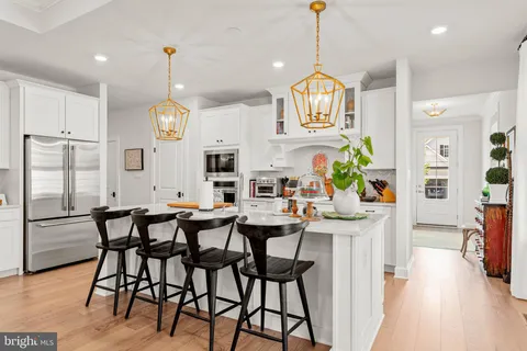 a view of a dining room and livingroom with furniture wooden floor a chandelier