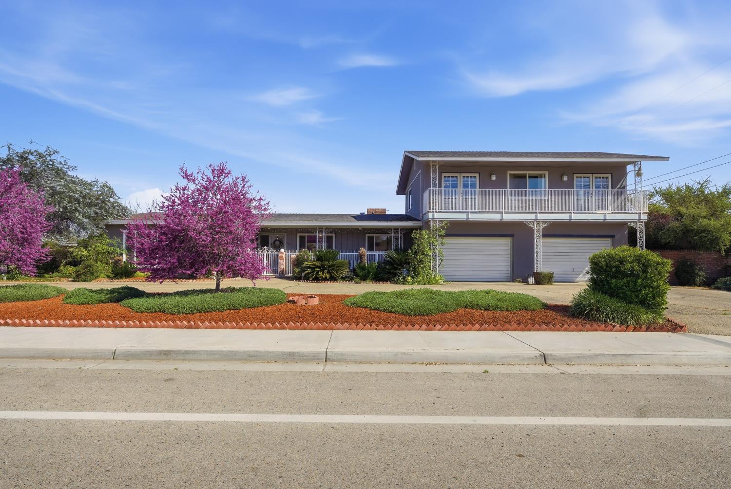 a front view of house with yard and trees in the background