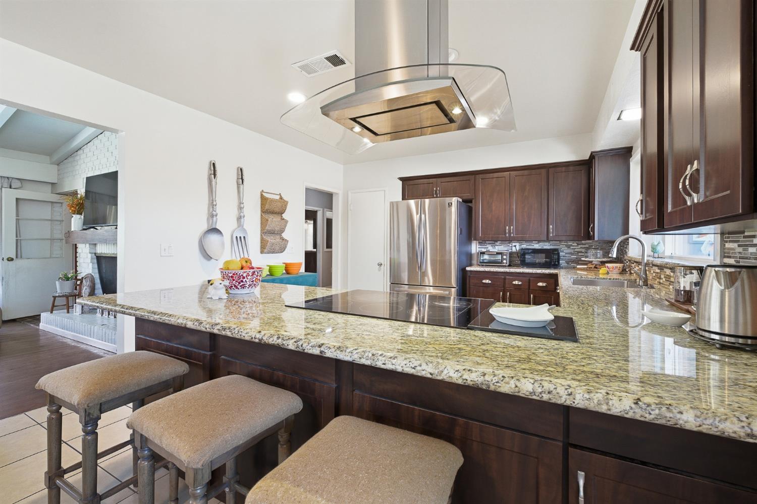 574 North Frankwood Avenue Reedley, CA 93654 - Photo 12 of 37 a kitchen with granite countertop a sink cabinets and stainless steel appliances