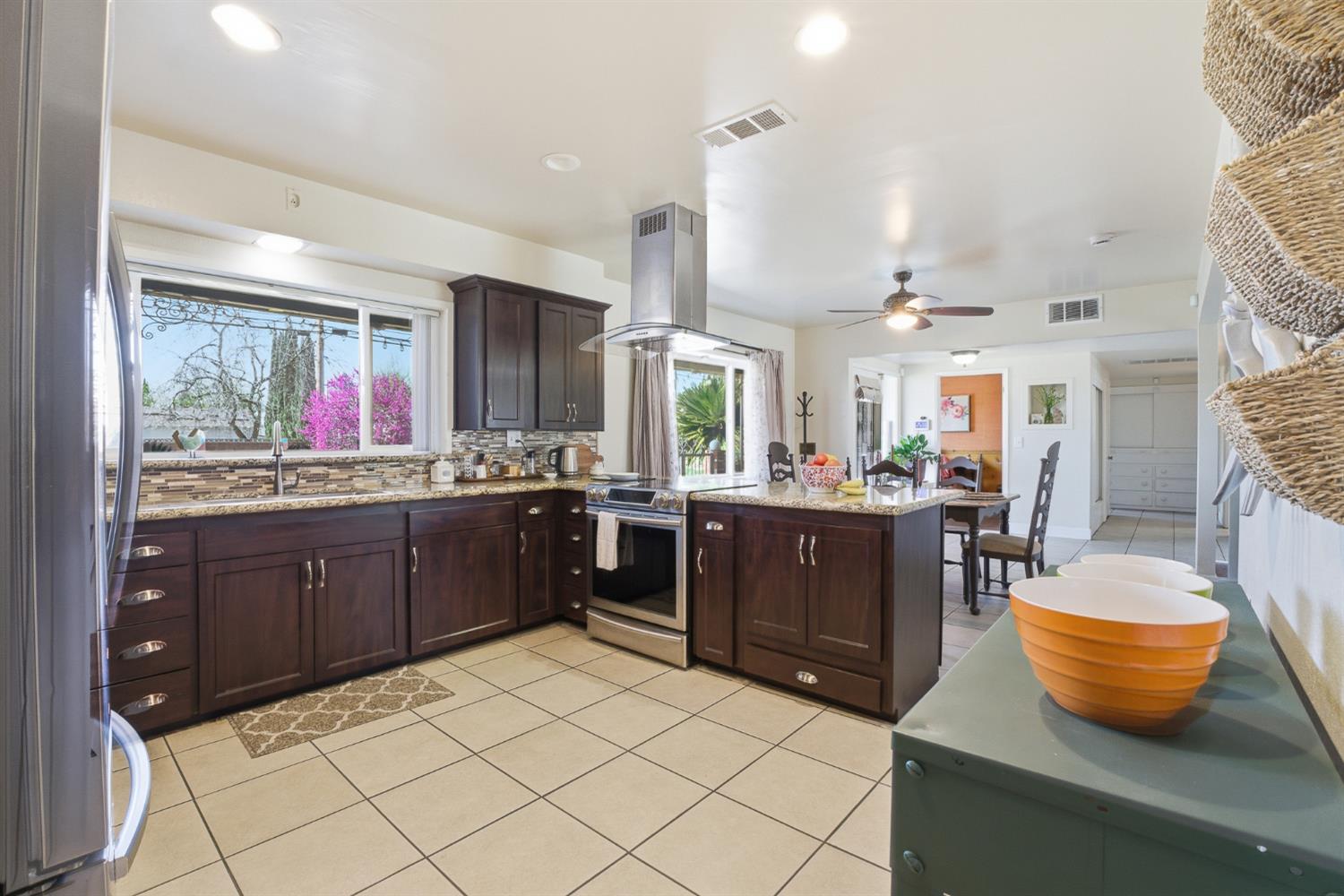 574 North Frankwood Avenue Reedley, CA 93654 - Photo 13 of 37 a large kitchen with stainless steel appliances kitchen island granite countertop wooden cabinets and a granite counter tops