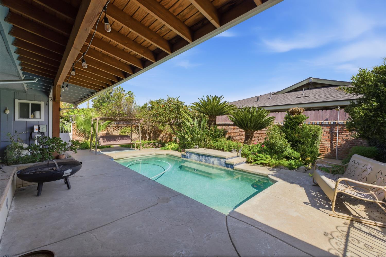 574 North Frankwood Avenue Reedley, CA 93654 - Photo 32 of 37 a view of a patio with table and chairs potted plants and a palm tree