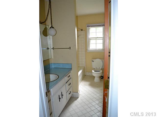 1447 McIlroy Road Charlotte, NC 28212 - Photo 10 of 12 a bathroom with a granite countertop toilet a sink and a mirror