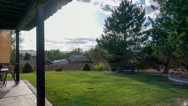 1797 Sunset Road Enoch, UT 84721 - Photo 57 of 80 Expansive backyard featuring a manicured lawn, established trees, and perimeter fencing