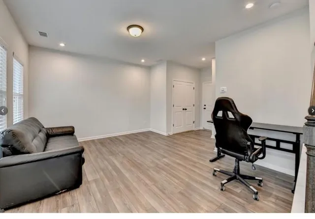 a living room with furniture and a wooden floor