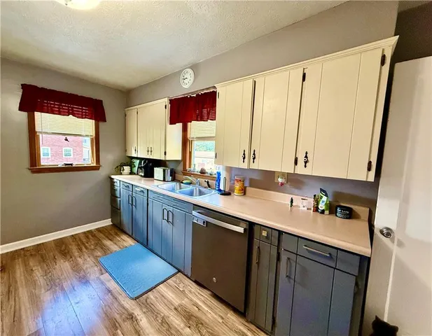 a kitchen with a sink appliances cabinets and a window