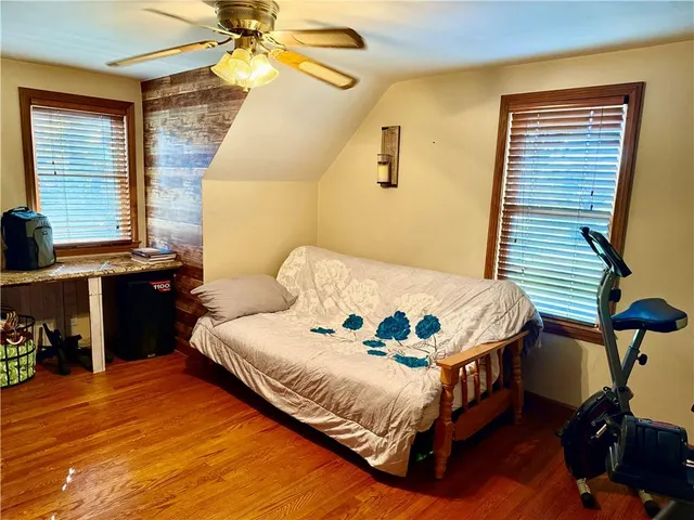 a bedroom with a bed and wooden floor