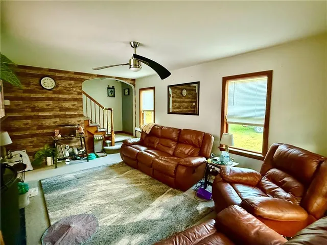 a living room with furniture ceiling fan and a rug