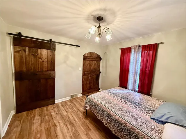 a bedroom with a bed and a chandelier
