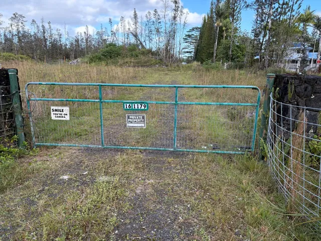 a view of a street with houses and trees in the background