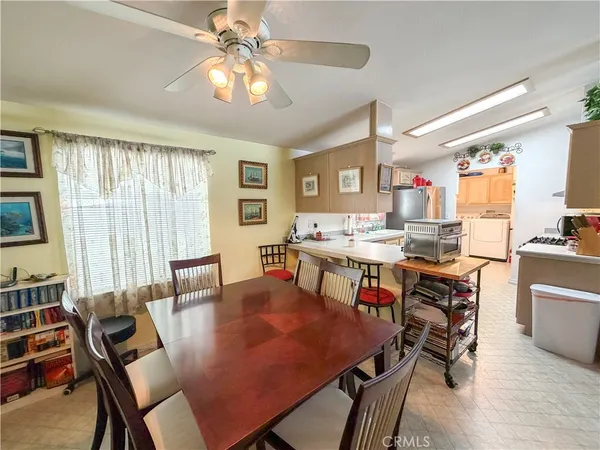 a living room with furniture a chandelier and a dining table