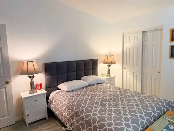 a bedroom with a bed and flat tv screen tv on the table