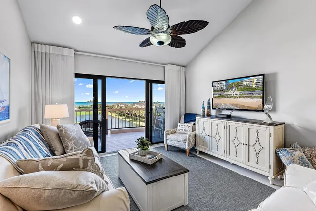 a living room with furniture ceiling fan and a flat screen tv