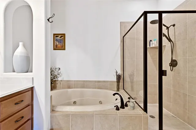 a bathroom with a tub sink and mirror
