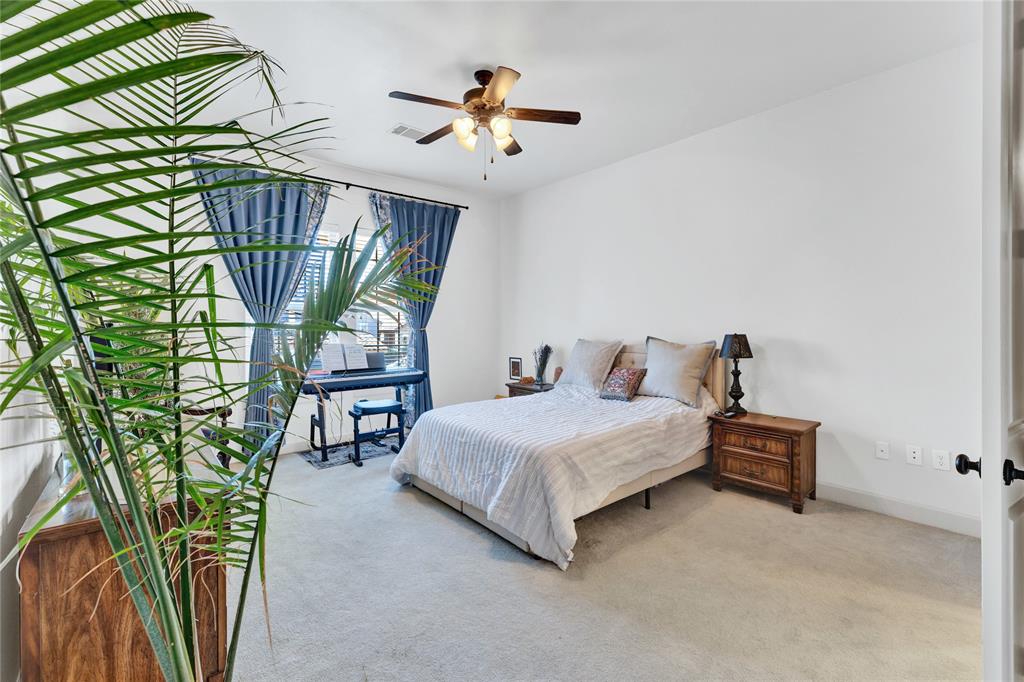 610 Via Ravello, Unit 207 Irving, TX 75039 - Photo 8 of 34 a bedroom with a bed windows and a chandelier