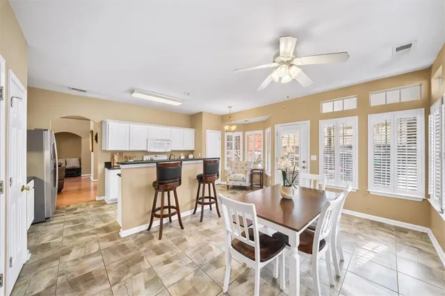 a dining room with stainless steel appliances a dining table and chairs