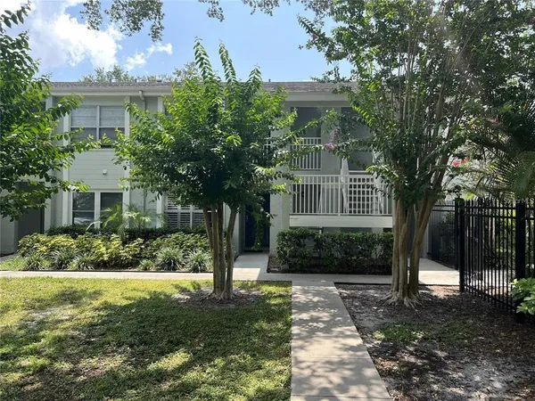 a front view of a house with a yard and potted plants