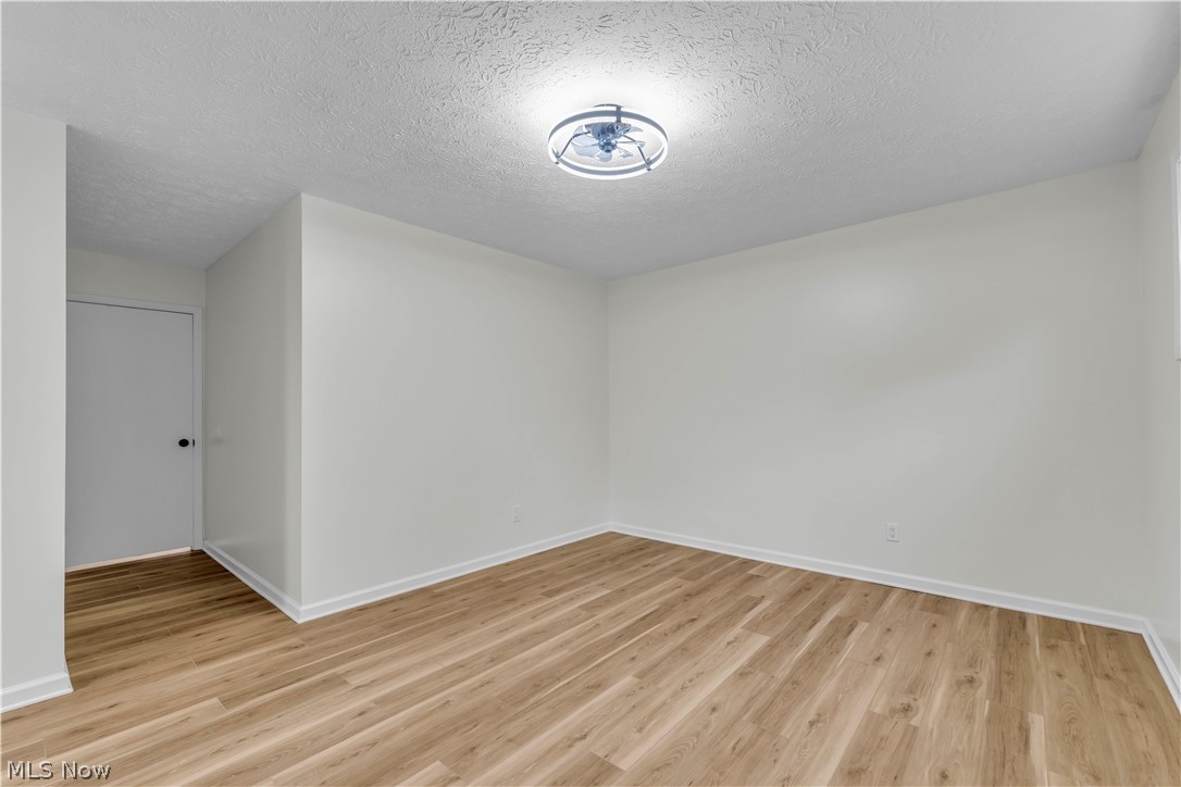 10763 Gate Post Road Strongsville, OH 44149 - Photo 25 of 45 Room featuring wood-finish flooring, white baseboards, and a semi-flush mount ceiling light fixture