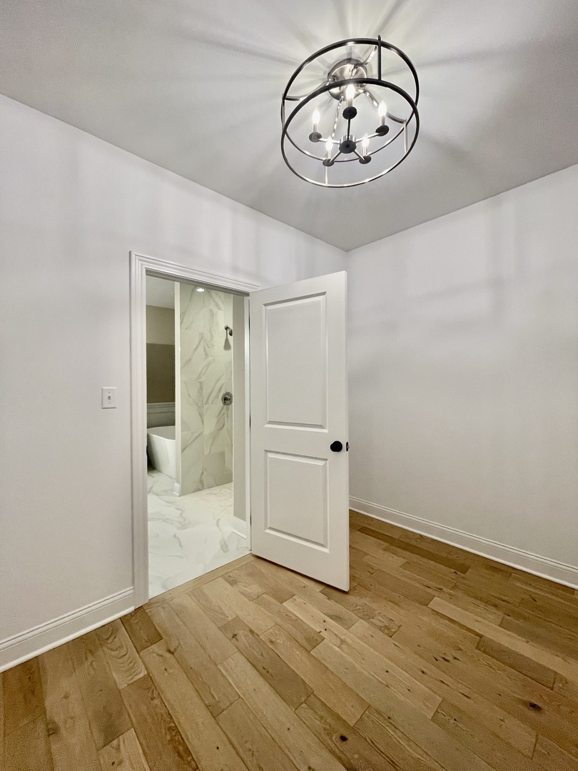 15919 Prairie View Court, Unit T2 New Lenox, IL 60451 - Photo 21 of 29 a view of a hallway with wooden floor and a chandelier