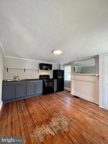 a large kitchen with wooden floors and stainless steel appliances