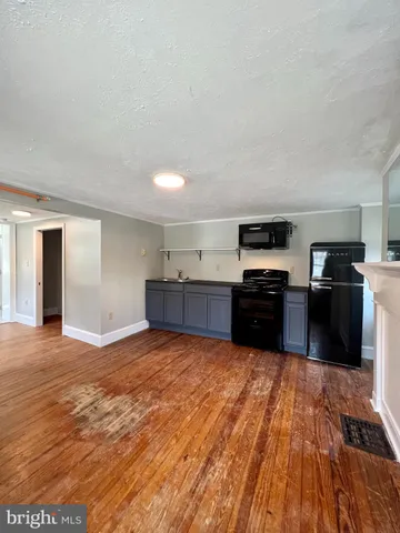 a large kitchen with wooden floors and stainless steel appliances