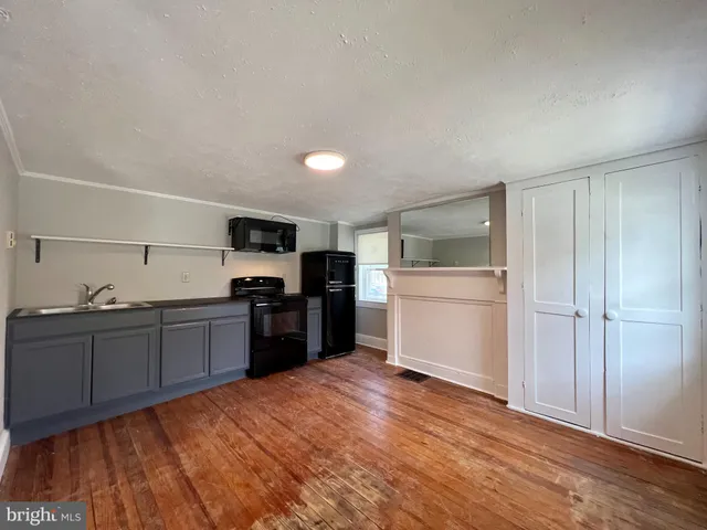 a kitchen with granite countertop a refrigerator stove top oven and sink