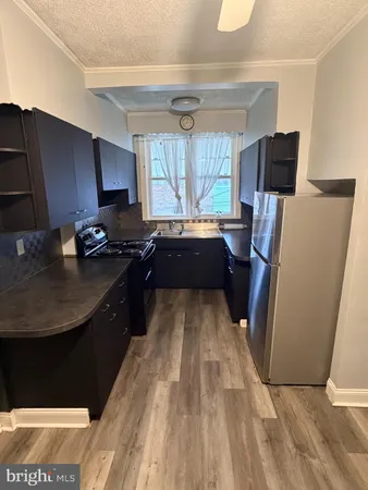 a kitchen with kitchen island granite countertop a sink stove and refrigerator