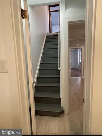 a view of a hallway with wooden floor and entryway