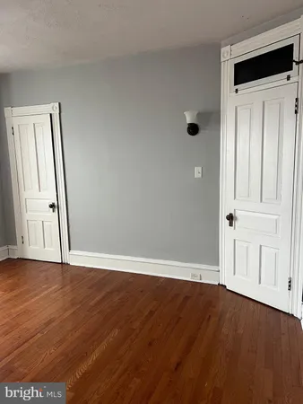 an empty room with wooden floor and closet