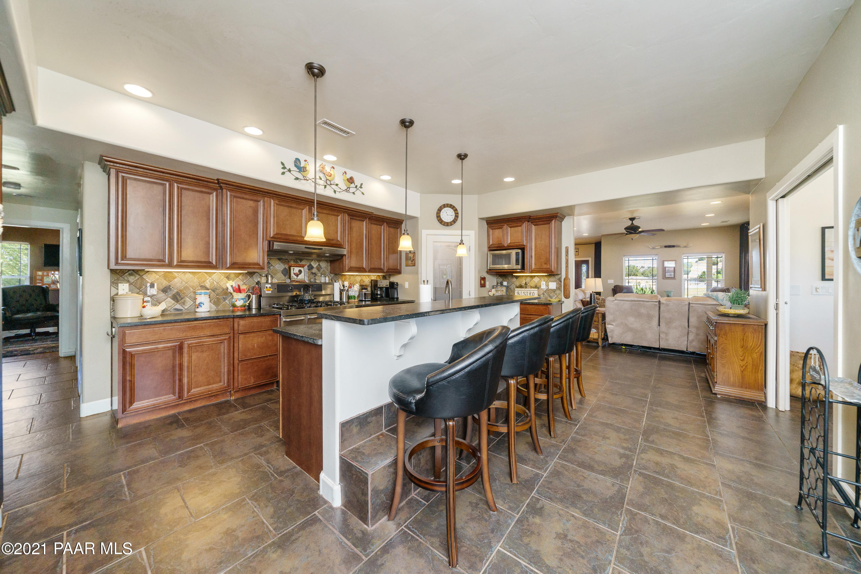 18000 North Lower Territory Road Prescott, AZ 86305 - Photo 13 of 42 a kitchen with stainless steel appliances kitchen island granite countertop a refrigerator a stove a sink a dining table and chairs