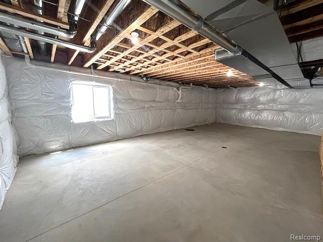 2670 Riley Center Road Memphis, MI 48041 - Photo 22 of 24 Expansive unfinished space featuring a concrete floor, insulated walls, exposed ceiling joists, and a window