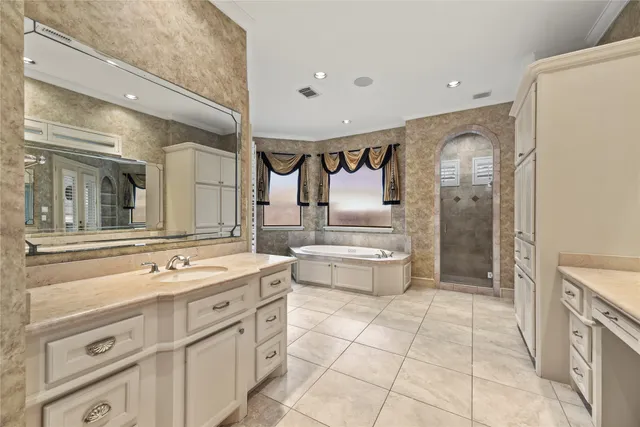 a spacious bathroom with a double vanity sink a mirror and a bathtub